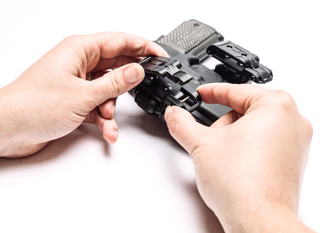Person using Latch system on Belt-Lok Mod for quick removal with Total Eclipse 2.0 Outside the Waistband Holster