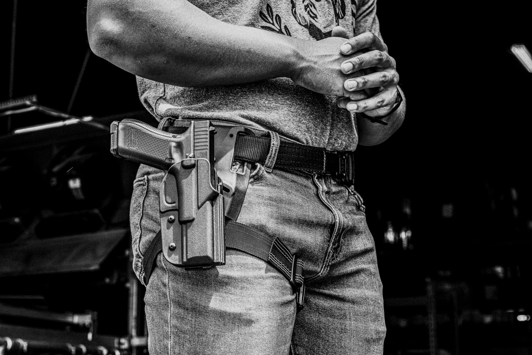 Person wearing Signature Outside the Waistband (OWB) Holster mounted onto Duty Drop and Offset Attachment with Thigh Strap and Instructor's Gun Belt with AustriAlpin COBRA® Buckle 